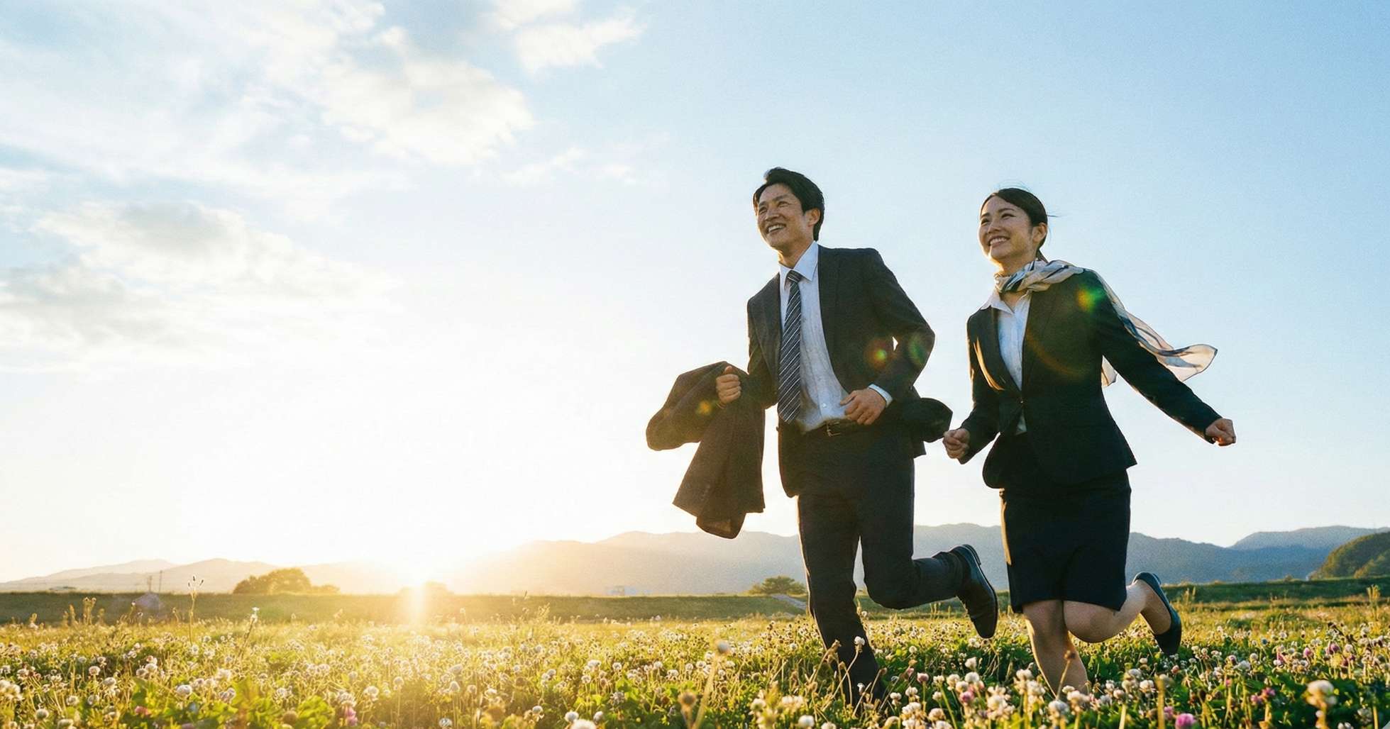 青空の下、笑顔で駆け出すビジネスパーソンの集団
